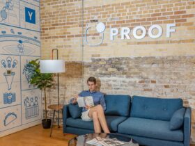 man sitting on blue sofa while reading book