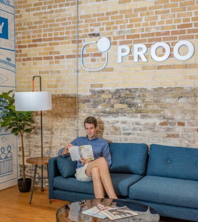 man sitting on blue sofa while reading book