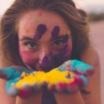 woman with coloring powders on face and hand