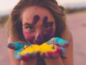 woman with coloring powders on face and hand