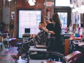 man standing beside man sitting on barber chair