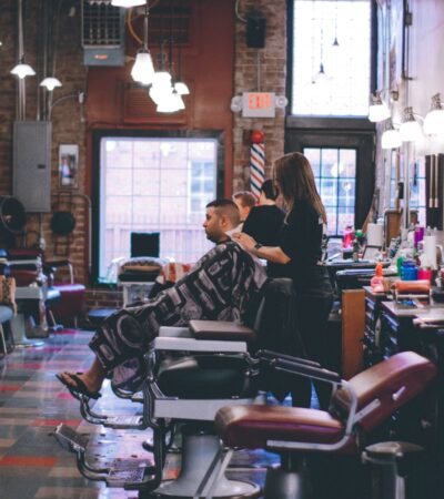 man standing beside man sitting on barber chair