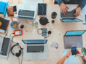 people sitting down near table with assorted laptop computers